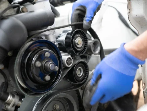 Mechanic repairing fluid leaks and replacing worn belts in the workshop